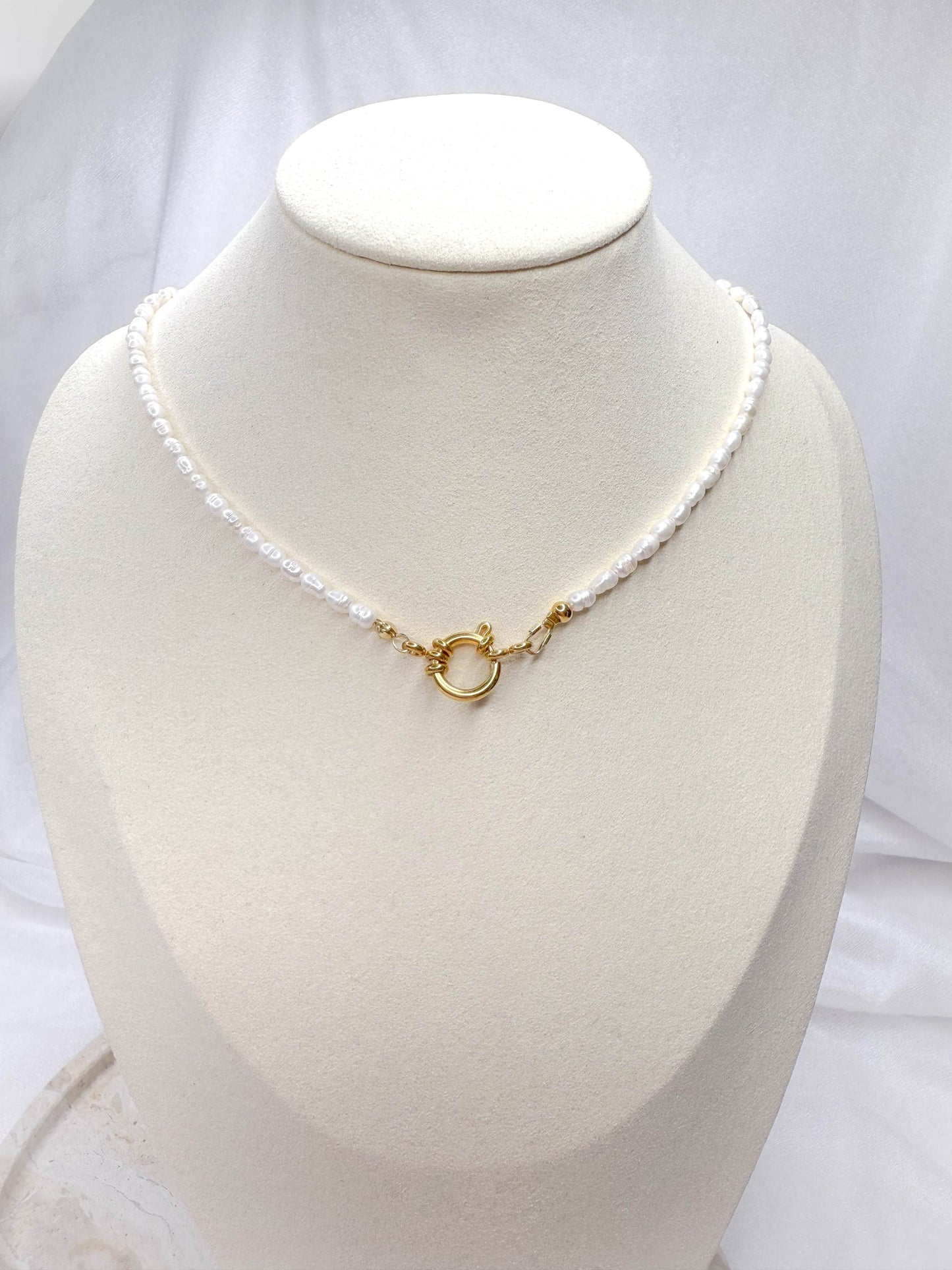 Handgefertigte Süßwasserperlen-Kette ‚Hannah‘ mit dekorativem Verschluss in Gold. Die elegante Perlenkette kann vielseitig getragen werden – mit dem Verschluss vorne als modernes Highlight oder klassisch nach hinten gedreht. Zeitloses Schmuckstück mit echten Süßwasserperlen, perfekt für jeden Anlass.