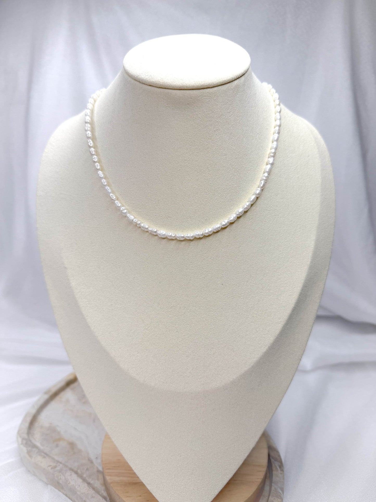 Handgefertigte Süßwasserperlen-Kette ‚Hannah‘ mit dekorativem Verschluss in Gold. Die elegante Perlenkette kann vielseitig getragen werden – mit dem Verschluss vorne als modernes Highlight oder klassisch nach hinten gedreht. Zeitloses Schmuckstück mit echten Süßwasserperlen, perfekt für jeden Anlass.